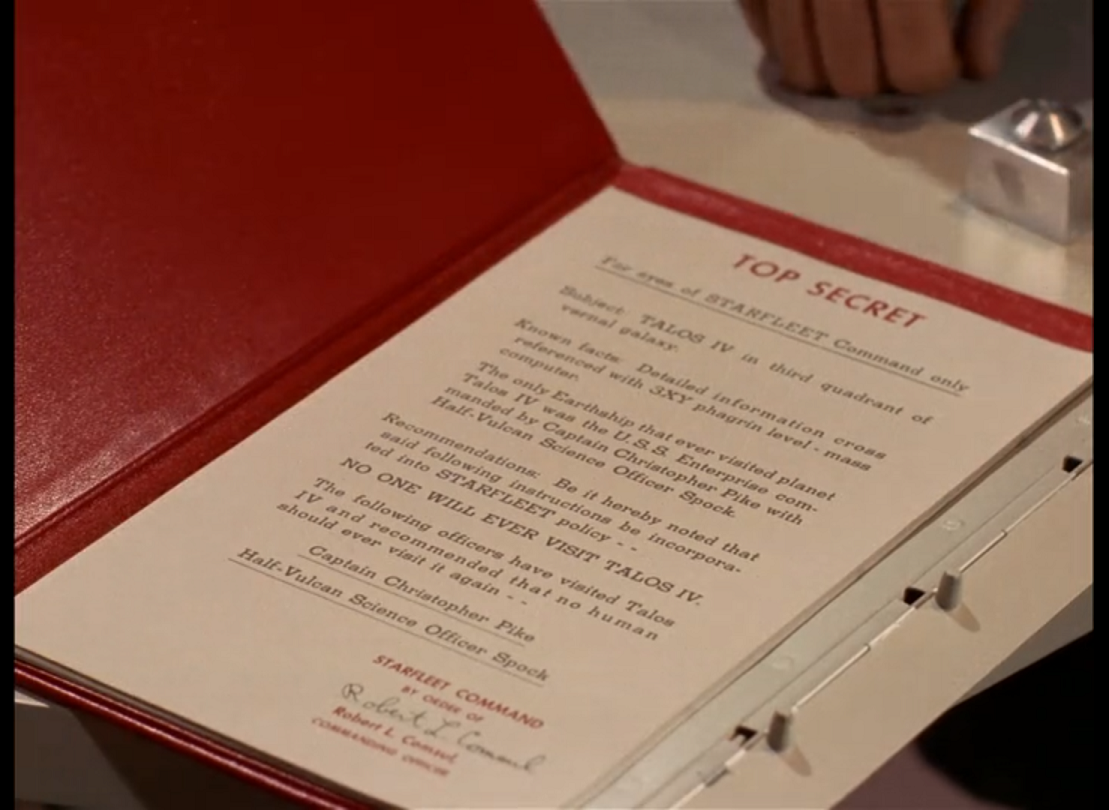 A paper inside a red folder on a tabletop. 