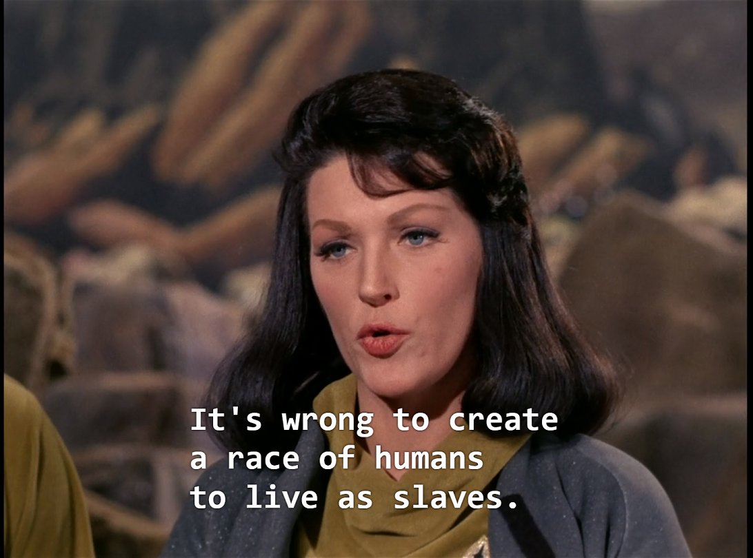 Number One, a white woman with long dark hair wearing a blue landing party jacket, saying,”It’s wrong to create a race of humans to live as slaves.”