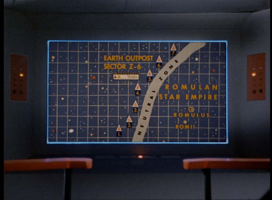 The bridge screen of the Enterprise, showing a map of a star section. Seven numbered triangles are arranged in a line along a vertical wavy gray line labeled Neutral Zone. Text on the left of the line reads Earth Outpost Sector Z-6; text on the right of it leads Romulan Star Empire. Two small orbs on that side are labeled Romulus and RomII.